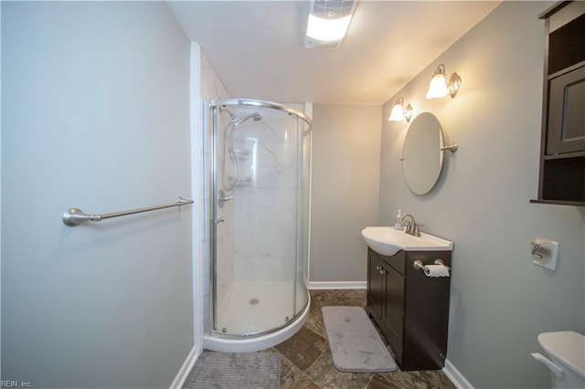 bathroom featuring vanity, baseboards, and a stall shower