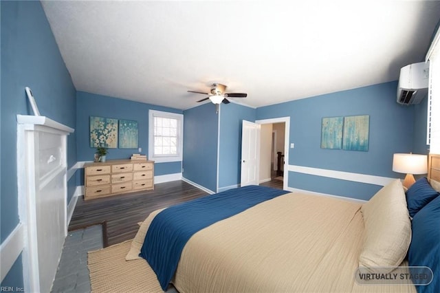 bedroom with ceiling fan, an AC wall unit, dark wood-type flooring, and baseboards