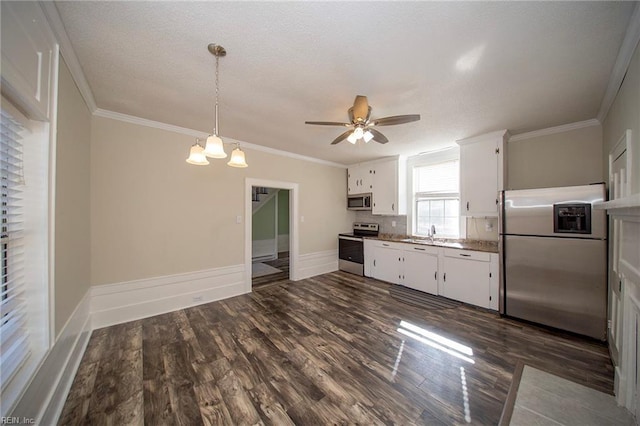 kitchen featuring appliances with stainless steel finishes, crown molding, and white cabinetry