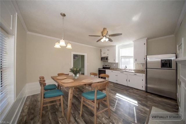 dining room featuring dark wood finished floors, ceiling fan with notable chandelier, crown molding, and baseboards