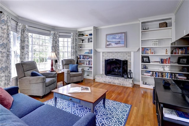 living area featuring a fireplace, built in shelves, light wood-style floors, and ornamental molding