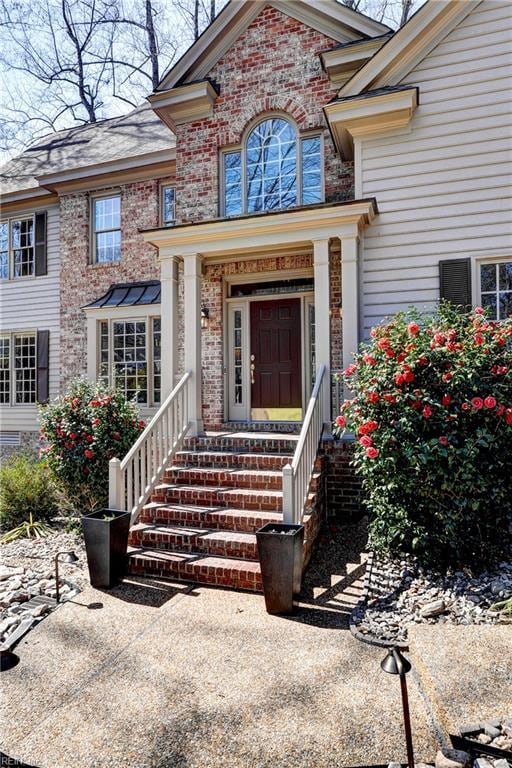 view of exterior entry featuring brick siding