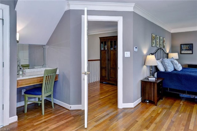 bedroom with ornamental molding, baseboards, and wood finished floors