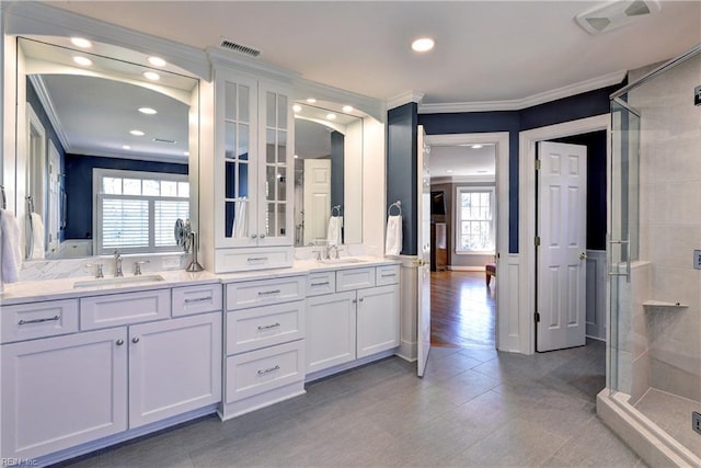 bathroom with a sink, visible vents, and ornamental molding