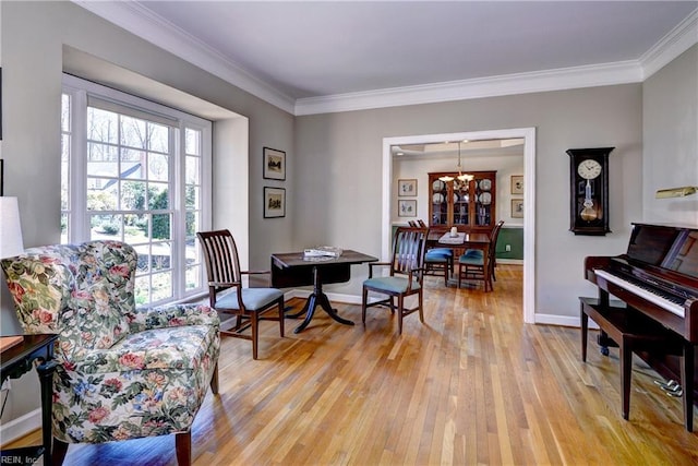 sitting room featuring light wood-type flooring, baseboards, and ornamental molding