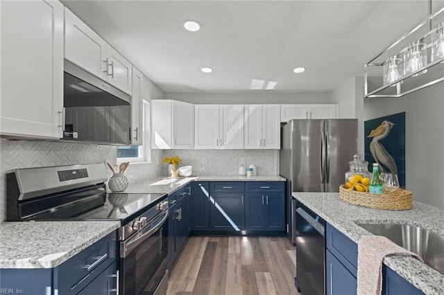 kitchen with blue cabinets, tasteful backsplash, dark wood finished floors, appliances with stainless steel finishes, and white cabinets