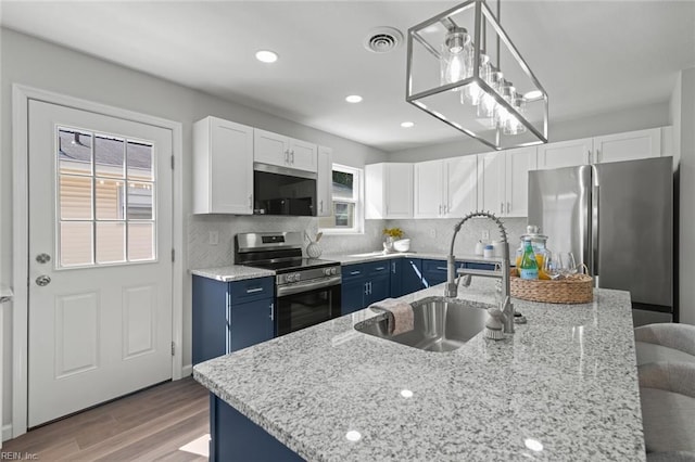 kitchen featuring blue cabinets, visible vents, a sink, appliances with stainless steel finishes, and white cabinets