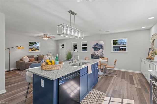 kitchen with dishwasher, dark wood-type flooring, blue cabinets, and a sink