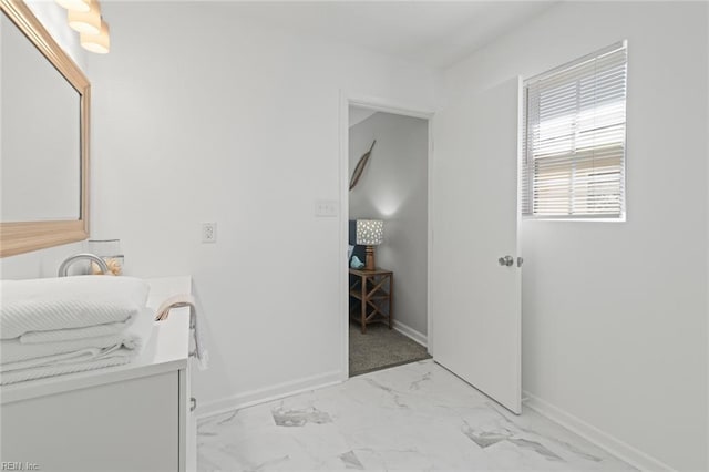 clothes washing area with baseboards and marble finish floor