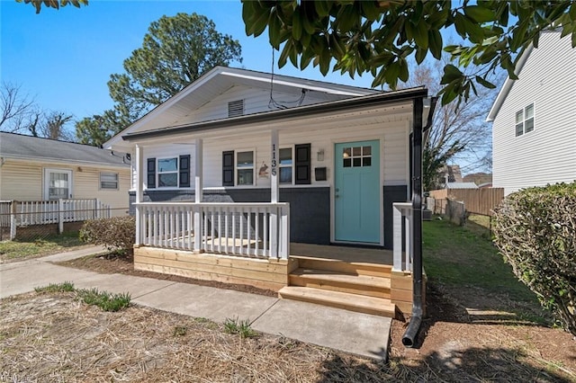 bungalow-style house with fence and covered porch