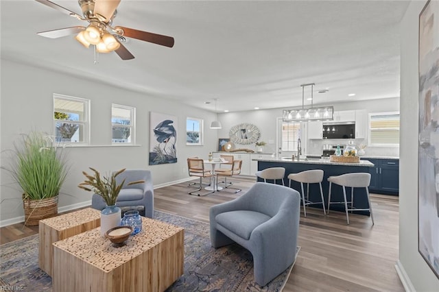 living room featuring recessed lighting, a ceiling fan, baseboards, and wood finished floors