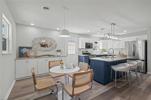 dining space featuring visible vents, recessed lighting, baseboards, and wood finished floors