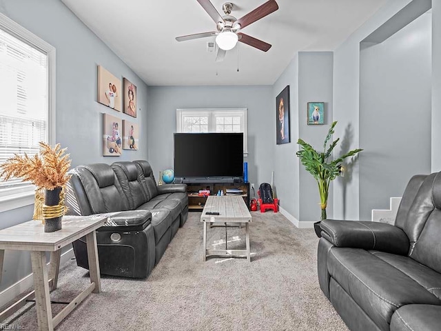 carpeted living room featuring a ceiling fan and baseboards