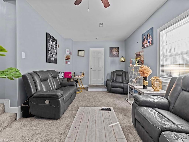 carpeted living room with baseboards and a ceiling fan