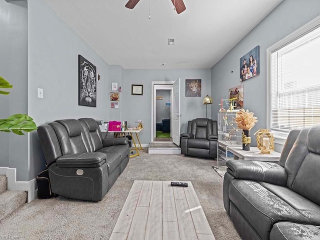 carpeted living room with visible vents, baseboards, and ceiling fan