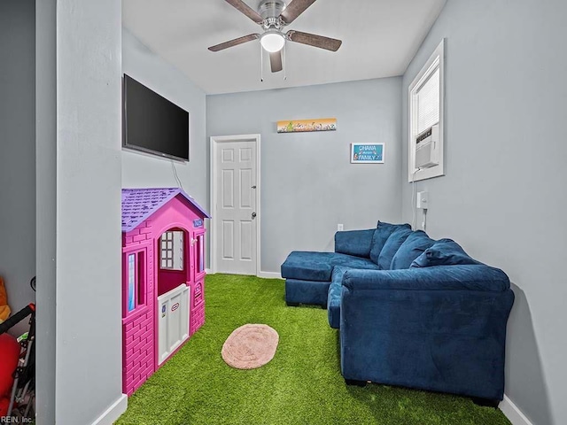 carpeted living area with cooling unit, baseboards, and a ceiling fan