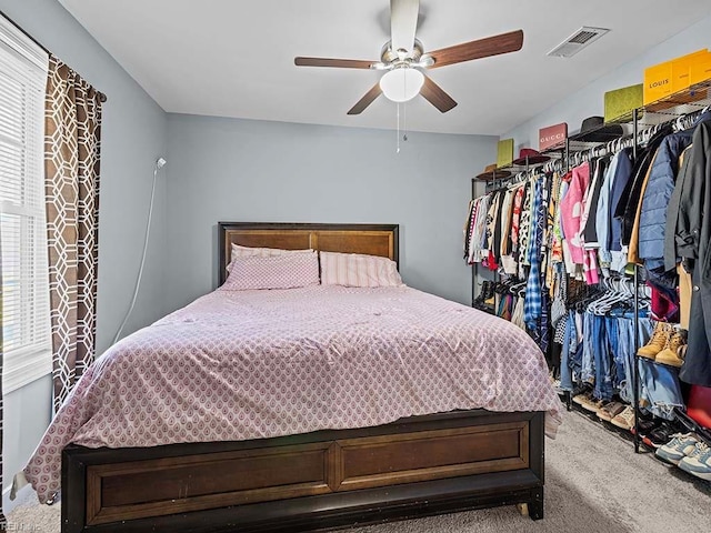 carpeted bedroom with visible vents and ceiling fan