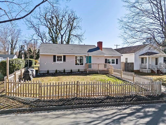 view of front of property with a fenced front yard, a wooden deck, and a chimney