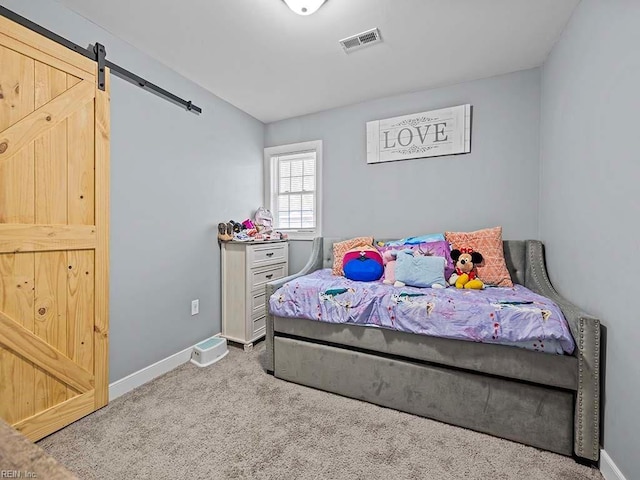 bedroom featuring a barn door, carpet, visible vents, and baseboards