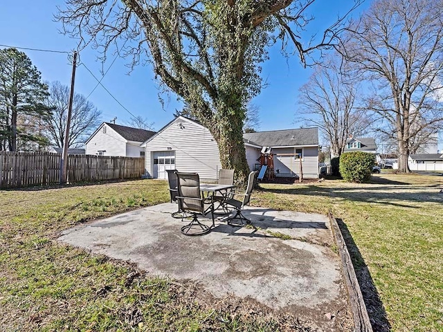 view of yard with an outdoor structure, a garage, a patio area, and fence