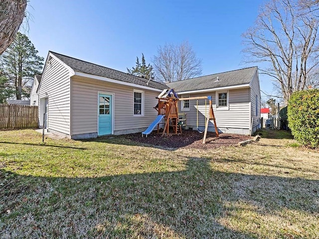 back of house with a yard, a playground, and fence