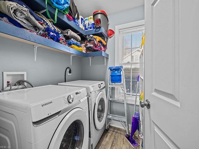 clothes washing area featuring laundry area, wood finished floors, and washer and clothes dryer