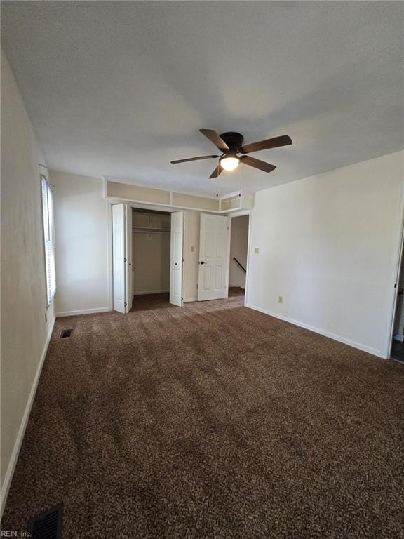 unfurnished bedroom with ceiling fan, carpet, visible vents, and baseboards