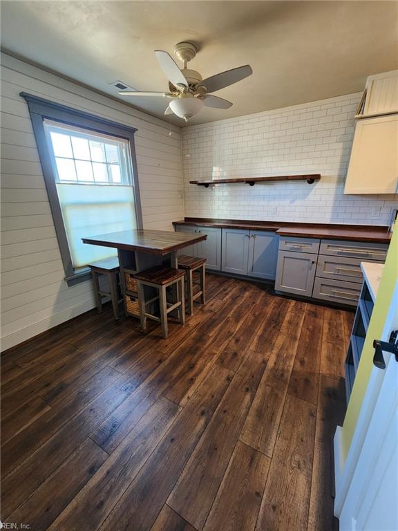 kitchen featuring a ceiling fan, visible vents, gray cabinets, dark wood-style flooring, and butcher block counters