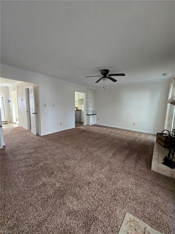 unfurnished living room featuring ceiling fan, baseboards, crown molding, and carpet