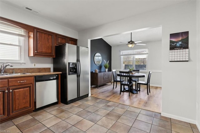 kitchen with visible vents, a sink, appliances with stainless steel finishes, light tile patterned floors, and ceiling fan