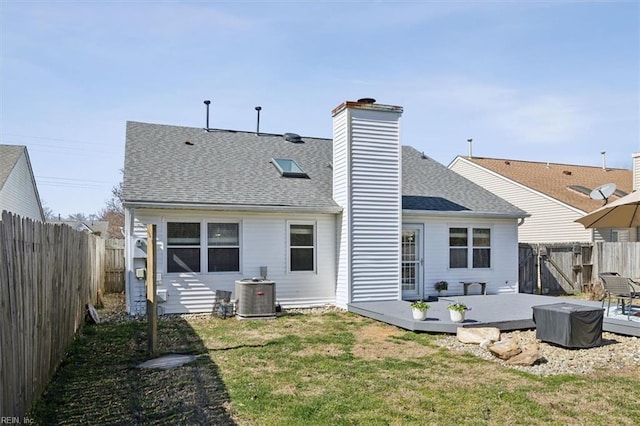 back of property featuring a yard, central AC unit, a wooden deck, and a fenced backyard