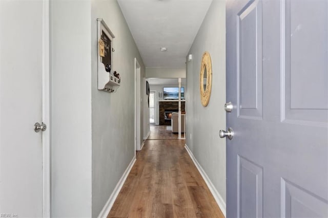 hallway featuring baseboards and wood finished floors