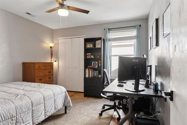 bedroom with a closet, visible vents, and ceiling fan