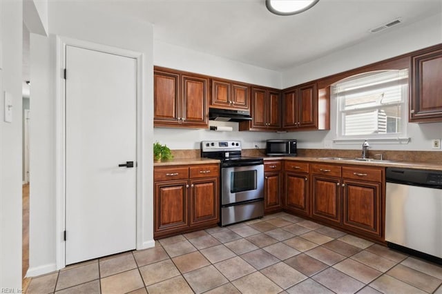 kitchen with visible vents, under cabinet range hood, a sink, stainless steel appliances, and light tile patterned floors