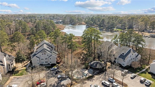 drone / aerial view featuring a wooded view and a water view