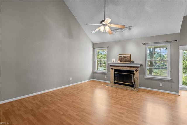 unfurnished living room featuring a high end fireplace, light wood-style flooring, and a healthy amount of sunlight