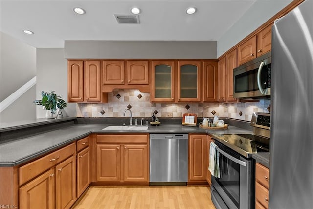 kitchen with dark countertops, visible vents, appliances with stainless steel finishes, and a sink