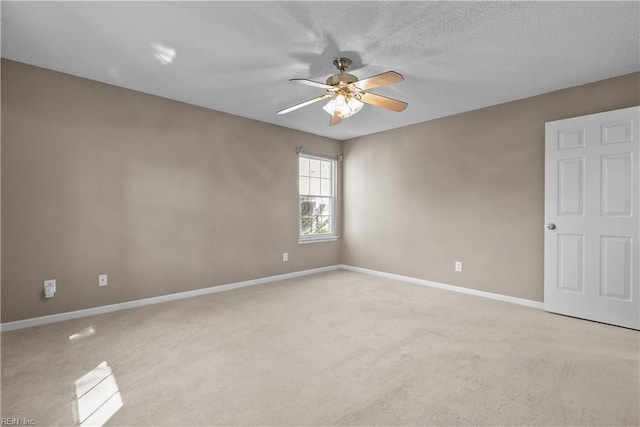 unfurnished room with light colored carpet, a textured ceiling, a ceiling fan, and baseboards