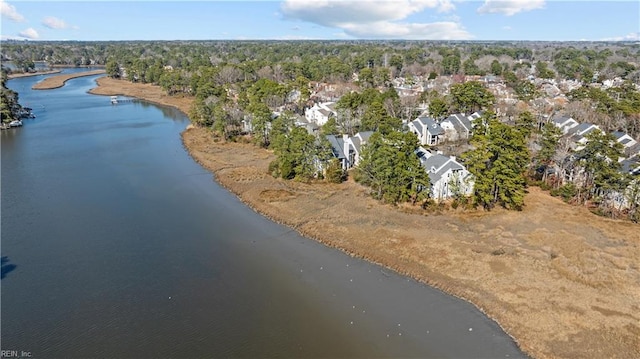 drone / aerial view with a wooded view and a water view