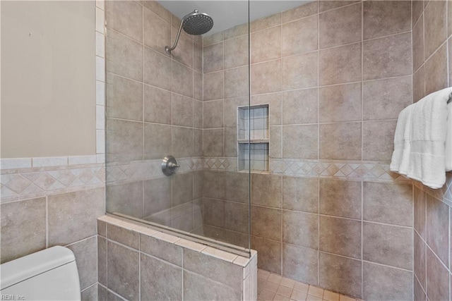 bathroom with toilet, tile walls, and walk in shower