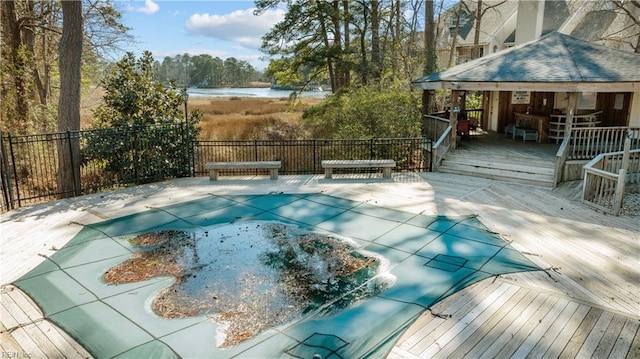 view of swimming pool with a deck with water view, a fenced in pool, and fence