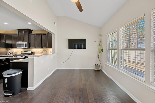 kitchen featuring backsplash, dark wood-type flooring, baseboards, lofted ceiling, and appliances with stainless steel finishes