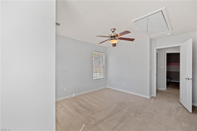 carpeted spare room with attic access, visible vents, and baseboards