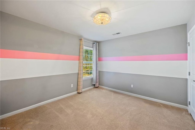 carpeted empty room featuring baseboards and visible vents