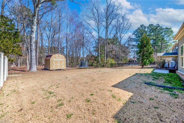 view of yard with an outdoor structure, a storage shed, a trampoline, and fence