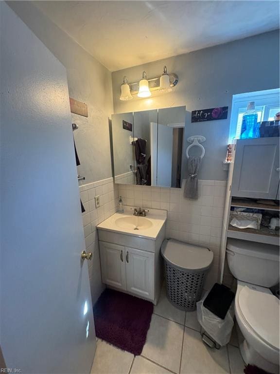 bathroom featuring vanity, tile walls, toilet, and tile patterned floors