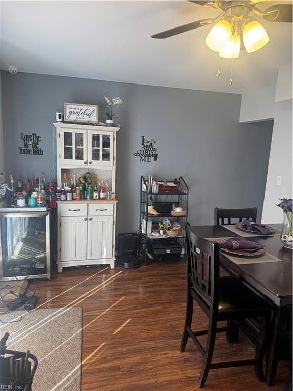 dining area with ceiling fan, beverage cooler, and dark wood-style flooring