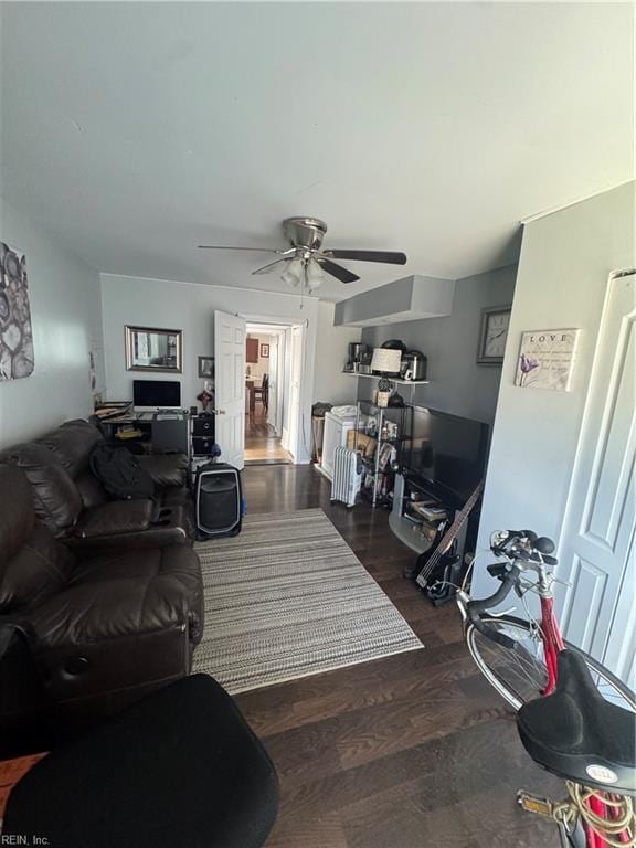 living room featuring ceiling fan and dark wood-style flooring