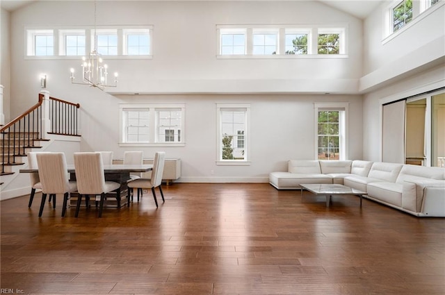 dining room with baseboards, a notable chandelier, dark wood finished floors, and high vaulted ceiling