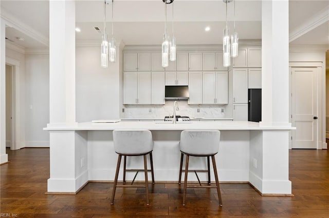 kitchen featuring a spacious island, freestanding refrigerator, light countertops, decorative backsplash, and dark wood-style flooring